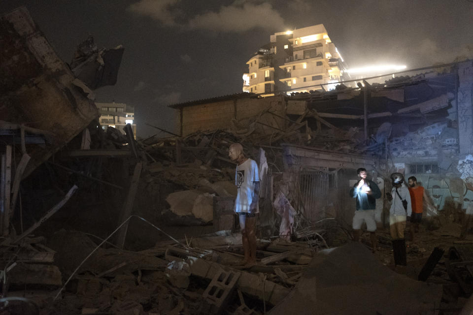 People look at the damage from a rocket fired from the Gaza Strip in Tel Aviv, Israel, Saturday, Oct. 7, 2023. (AP Photo/Moti Milrod)