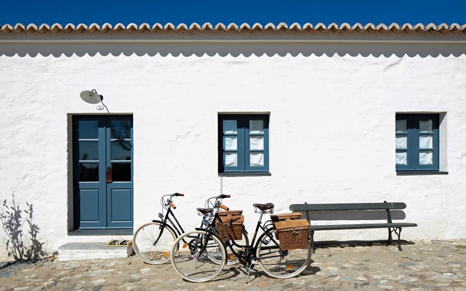 exterior of white building with bikes - NELSON GARRIDO