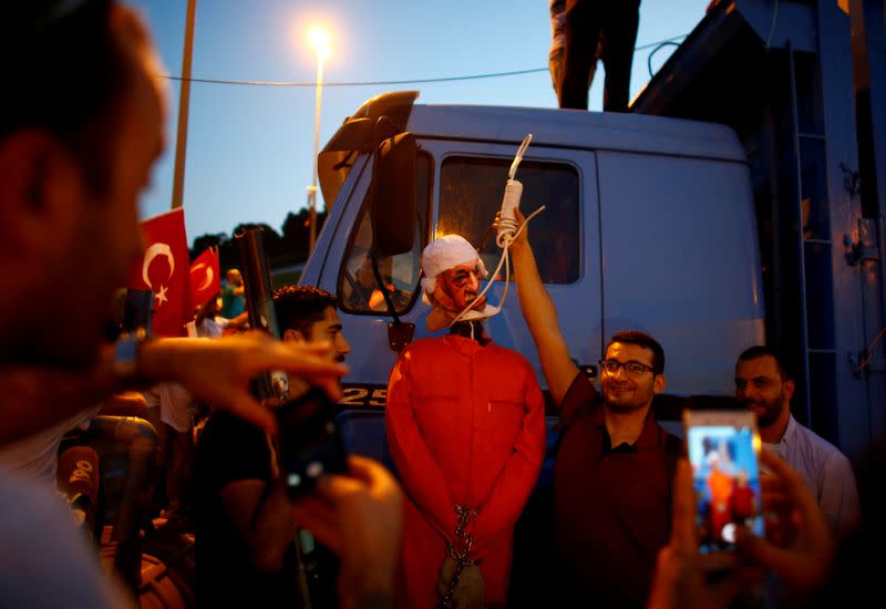 FILE PHOTO: A man poses with an effigy of U.S.-based Turkish cleric Fethullah Gulen during a ceremony marking the first anniversary of the attempted coup at the Bosphorus Bridge in Istanbul