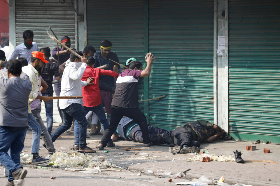 Activists of the Bangladesh Nationalist Party attack security officers during a protest in Dhaka, Bangladesh, Saturday, Oct. 28, 2023. Police in Bangladesh's capital fired tear gas to disperse supporters of the main opposition party who threw stones at security officials during a rally demanding the resignation of Prime Minister Sheikh Hasina and the transfer of power to a non-partisan caretaker government to oversee general elections next year. (AP Photo/Mahmud Hossain Opu)