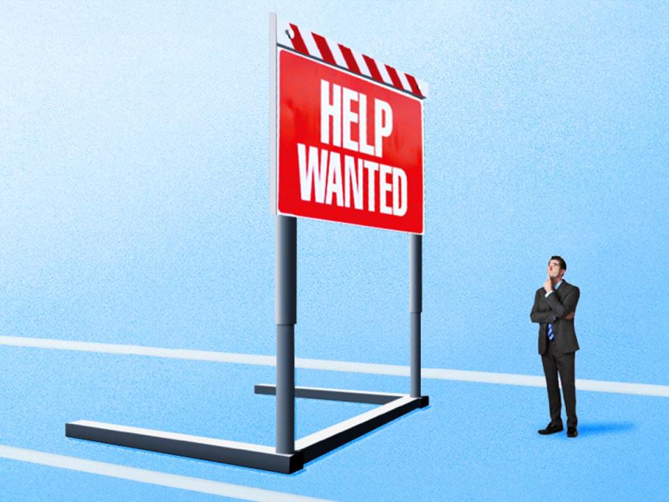 Businessman Looking at 'Help Wanted' Sign that appears as a Giant Hurdle Before him