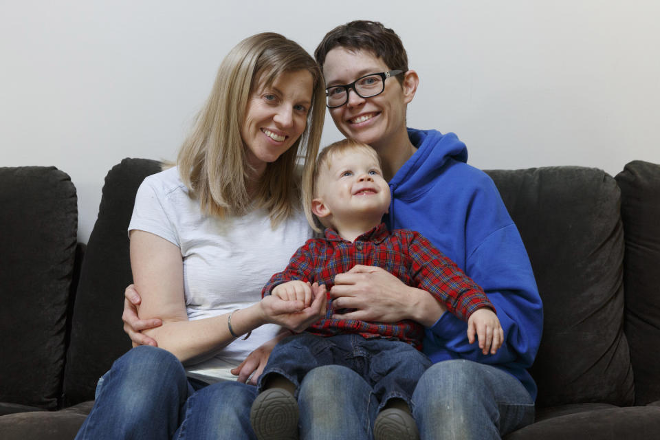 In this Friday, Nov. 16, 2018, photo, Anna Ford, left, and her partner, Sara Watson, pose with their son Eli, in the village of Saunderstown, in Narragansett, R.I. Three years after the landmark U.S. Supreme Court case that gave same-sex couples the right to marry nationwide, a patchwork of outdated state laws governing who can be a legal parent presents obstacles for many LGBTQ couples who start a family, lawyers say. (AP Photo/Michael Dwyer)