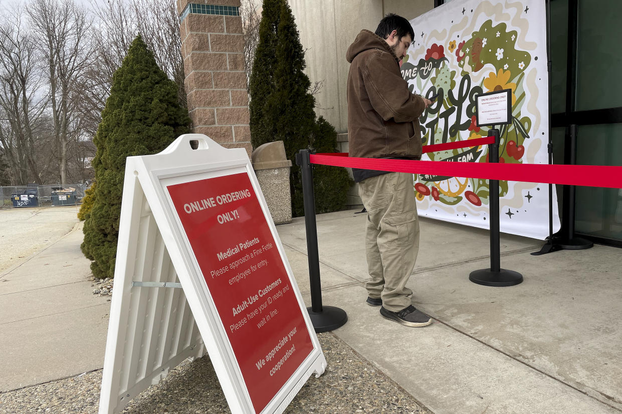 Samuel Gabbey, 32, of Mansfield, Conn., waits outside the Fine Fettle marijuana dispensary in Willimantic, Conn. on Tuesday, Jan. 10, 2023, for the opening of legal sales of recreational marijuana in Connecticut. As many as 40 dispensaries, along with dozens of other cannabis-related businesses, are expected to eventually open in Connecticut by the end of this year. (AP Photo/Pat Eaton-Robb)