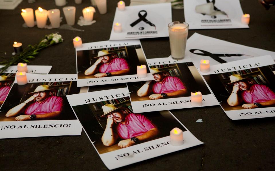 Pictures of murdered journalist Javier Valdez and the words "Justice! No to silence!" during a demonstration outside the Interior Ministry in Mexico City - Credit: Rebecca Blackwell/AP