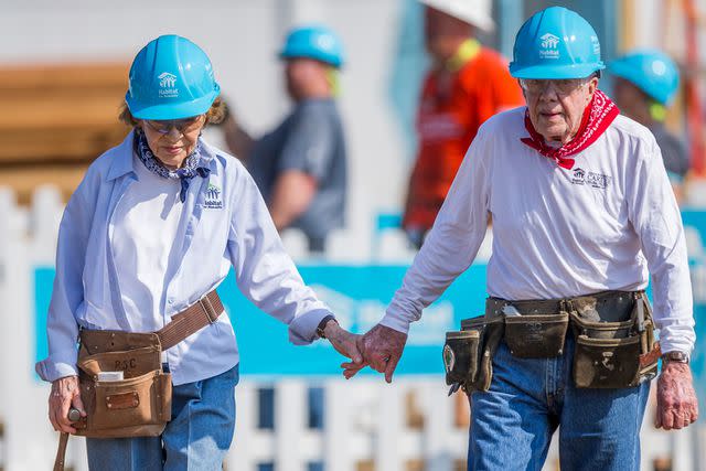 <p>Robert Franklin/South Bend Tribune via AP</p> Rosalynn and Jimmy Carter hold hands during the 2018 Jimmy & Rosalynn Carter Work Project with Habitat for Humanity