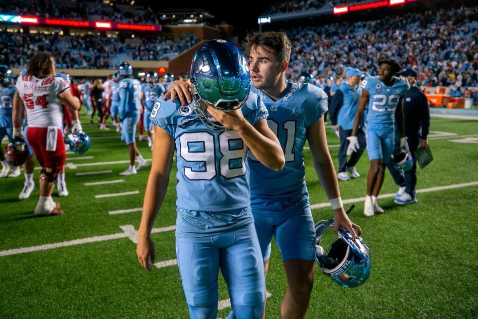 North Carolina punter Ben Kiernan (91) consoles kicker Noah Burnette (98) after Burnette missed a 35-yard field goal attempt in overtime to give N.C. State a 30-27 victory on Friday, November 25, 2022 at Kenan Stadium in Chapel Hill, N.C.