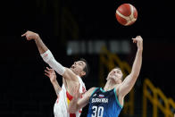 Spain's Alberto Abalde fights for a rebound with Slovenia's Zoran Dragic (30) during a men's basketball preliminary round game at the 2020 Summer Olympics, Sunday, Aug. 1, 2021, in Saitama, Japan. (AP Photo/Charlie Neibergall)