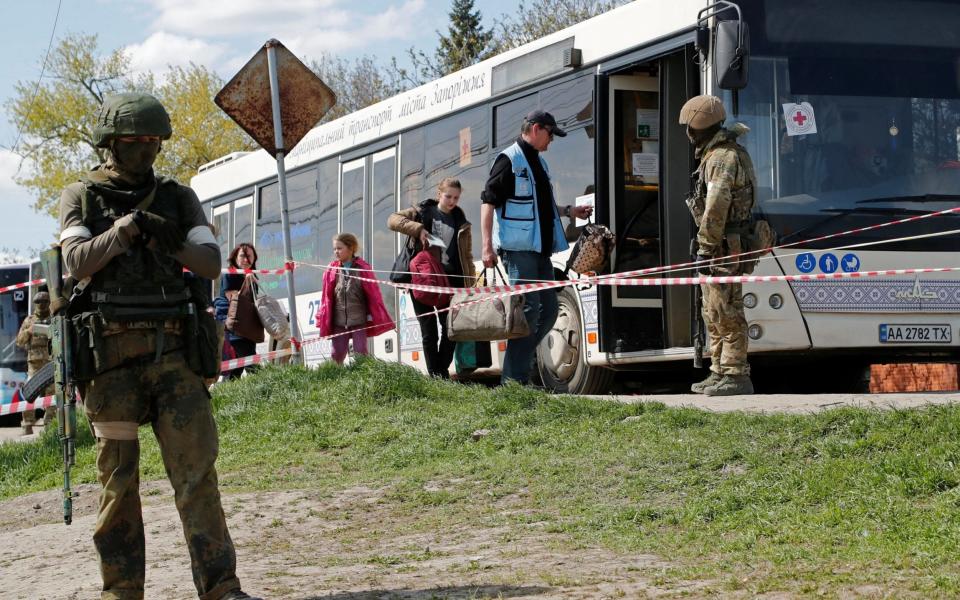 Civilians who left the area near Azovstal steel plant in Mariupol board a bus accompanied by a UN staff member near a temporary accommodation centre in the village of Bezimenne in the Donetsk Region - Alexander Ermochenko/Reuters