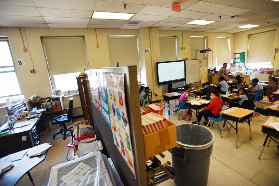 At Paterson's Roberto Clemente elementary school, multiple classes share a large room, separated by makeshift barriers of bookcases, corkboards, hospital dividers and filing cabinets that don't block the noise.