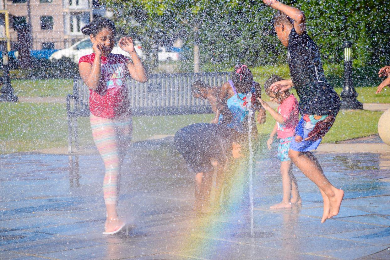FILE - Children run and jump through the water of the splash pad at Columbia County's annual Summer Beach Blast at Evans Towne Center Park in Evans, GA on Saturday, June 3, 2023. To beat the heat, government agencies recommend drinking water, wearing loose clothing and taking a cool bath or shower.