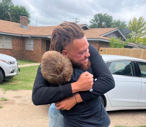 Brennan Ray hugs 11-year-old Shayden Walker. The two are neighbors. After Shayden stopped by Ray's house to look for new friends, the 23-year-old posted about him on TikTok and raised over $37,000 for the boy.