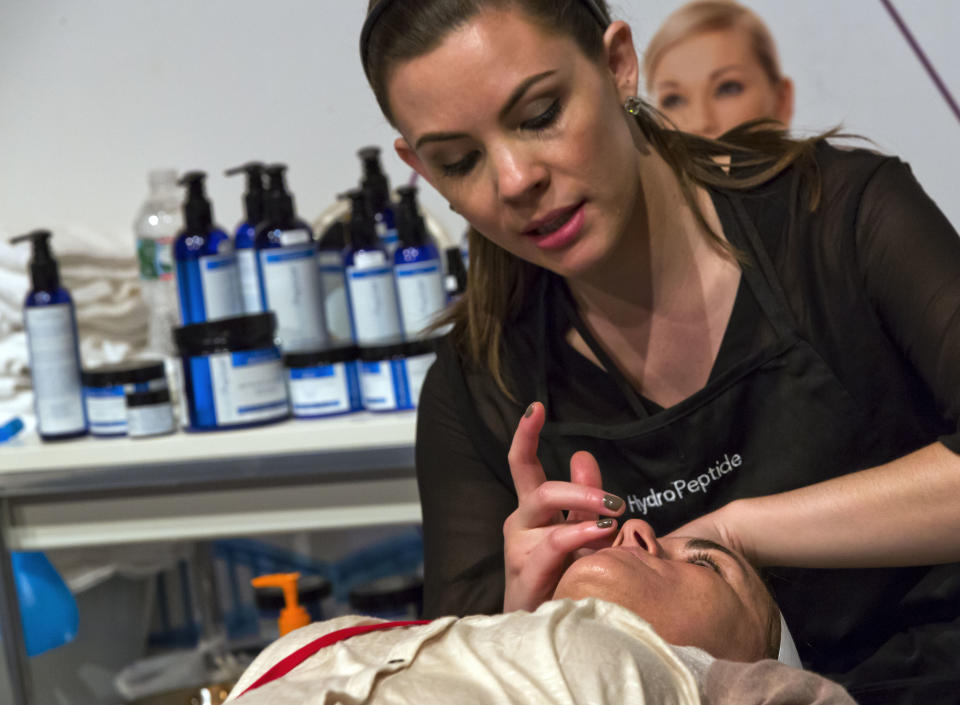 This Aug. 15, 2013 photo shows Erin Ferrill, with HydroPeptide, giving a treatment with their anti-aging skin care products, at the International Spa Association event, in New York. (AP Photo/Richard Drew)