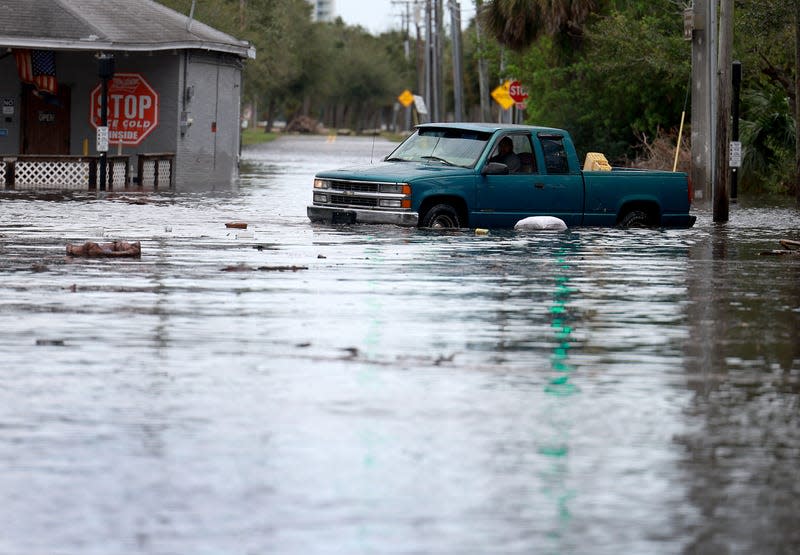 Photo of flooded street and car