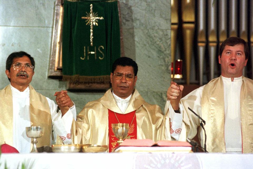 FILE - East Timor's Roman Catholic Bishop Carlos Ximenes Belo, center, holds hands with other priests during the Sunday's morning mass at Lisbon's Salesian religious order's church, on Sept. 12, 1999. Belo has been accused in a Dutch magazine article of sexually abusing boys in East Timor in the 1990s, rocking the Catholic Church in the impoverished nation and forcing officials at the Vatican and his religious order to scramble to provide answers. (AP Photo/Gael Cornier, File)