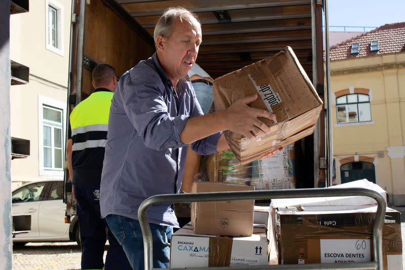 El ucraniano Yuri Kondra, de 51 años, descarga cajas de productos donados para los refugiados ucranianos en un centro de apoyo en Lisboa