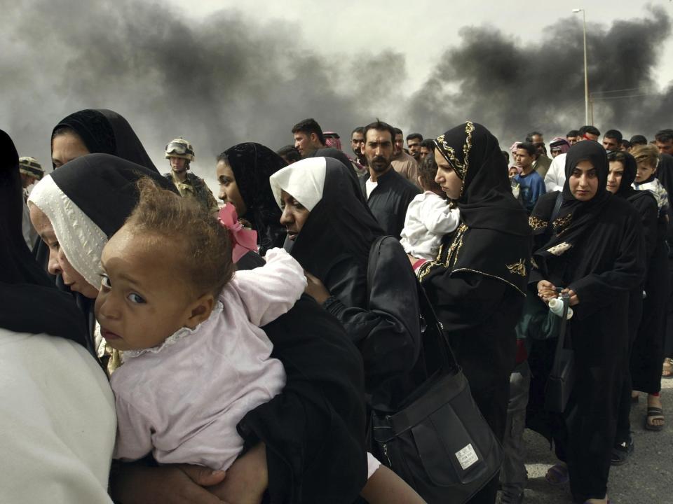 FILE - Iraqi women line up for a security check by British soldiers on the outskirts of Basra, as they try to flee from this southern Iraqi town on March 30, 2003. (AP Photo/Anja Niedringhaus, File)