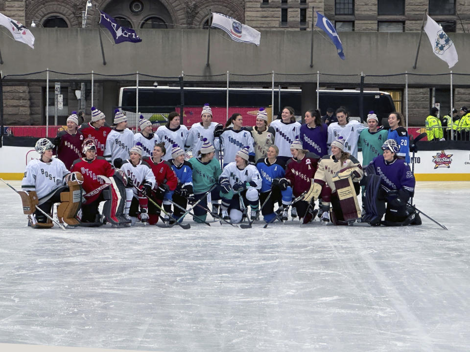 Professional Women’s Hockey League players pose on the ice at Nathan Phillips Square in Toronto, Thursday, Feb. 1, 2024, ahead of their 3-on-3 showcase at NHL All-Star Weekend. (AP Photo/Stephen Whyno)