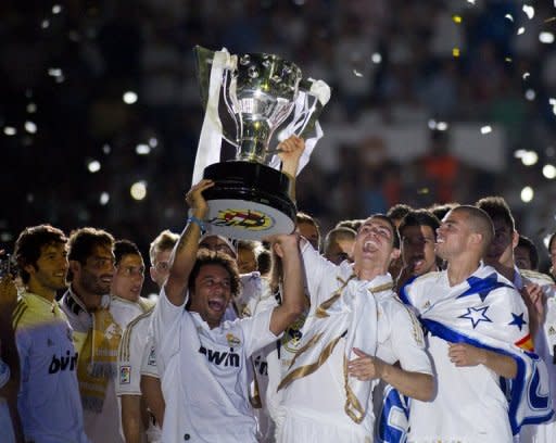 Real Madrid players hold the Spanish League trophy at the Santiago Bernabeu stadium in Madrid on May 13. Champions Real beat Mallorca 4-1 to break the 100-point barrier on the final day of La Liga season