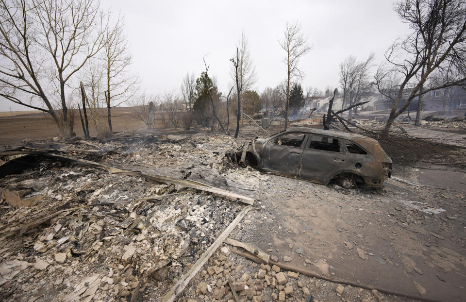 Debris surround the remains of homes burned by wildfires after they ripped through a development, Friday, Dec. 31, 2021, in Superior, Colo. Tens of thousands of Coloradans were driven from their neighborhoods by wind-whipped wildfires. (AP Photo/David Zalubowski)
