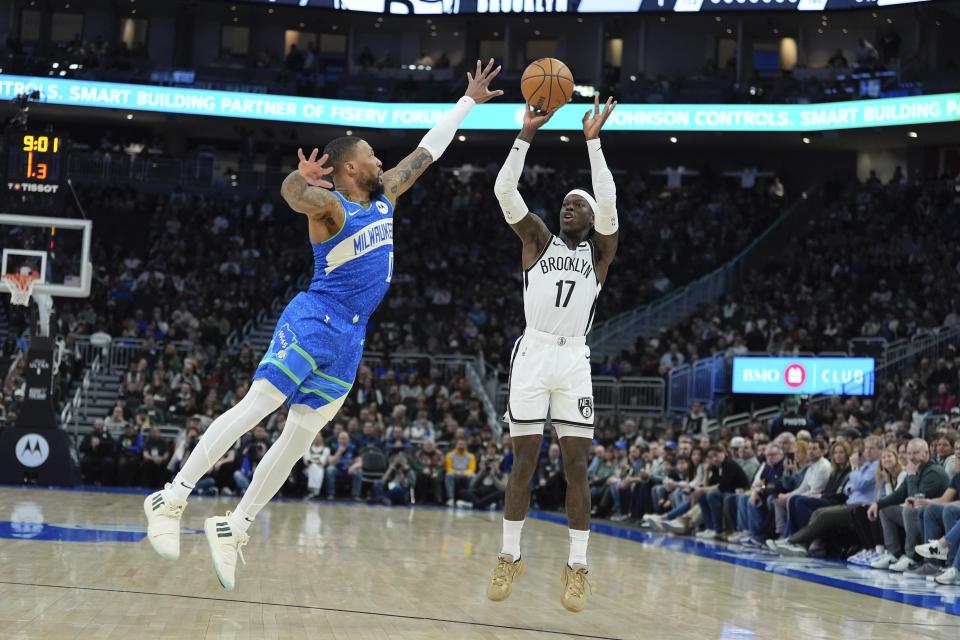 Brooklyn Nets' Dennis Schroder shoots past Milwaukee Bucks' Damian Lillard during the first half of an NBA basketball game Thursday, March 21, 2024, in Milwaukee. (AP Photo/Morry Gash)