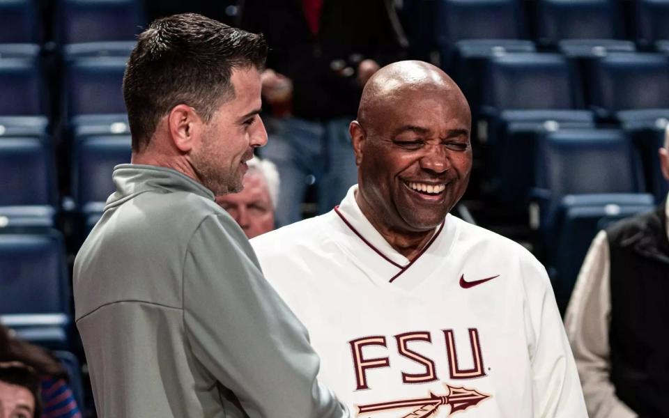Florida State head coach Leonard Hamilton speaks to a coach before a game.
