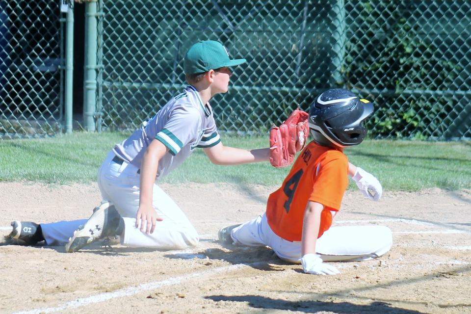 Dover pitcher Parker Redman, left, tags out Concord's Ethan Hill at home trying to score on a passed ball as both players await the umpire's call during Saturday's Cal Ripken 11-year-old, 60-foot championship game in Dover.