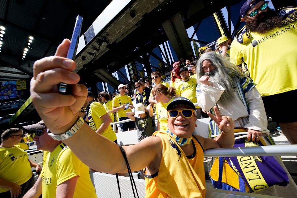 A fan takes a selfie with Nashville SC supporter Stephen Mason, aka Soccer Moses, during the inaugural match at GEODIS Park in Nashville, Tenn., Sunday, May 1, 2022.