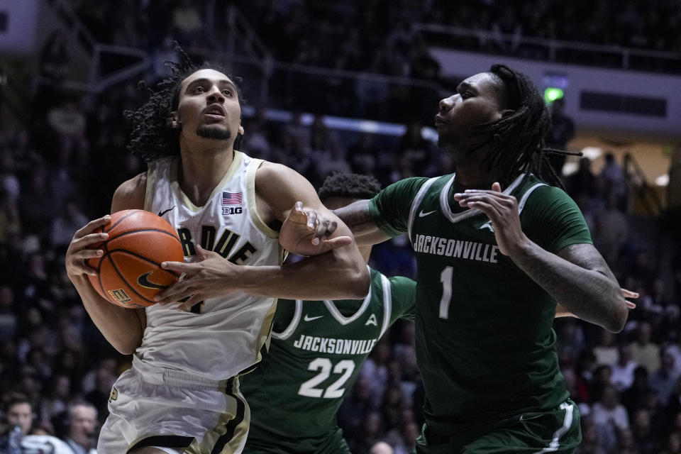 Purdue forward Trey Kaufman-Renn (4) is fouled by Jacksonville forward DeeJuan Pruitt (1) during the second half of an NCAA college basketball game in West Lafayette, Ind., Thursday, Dec. 21, 2023. (AP Photo/Michael Conroy)