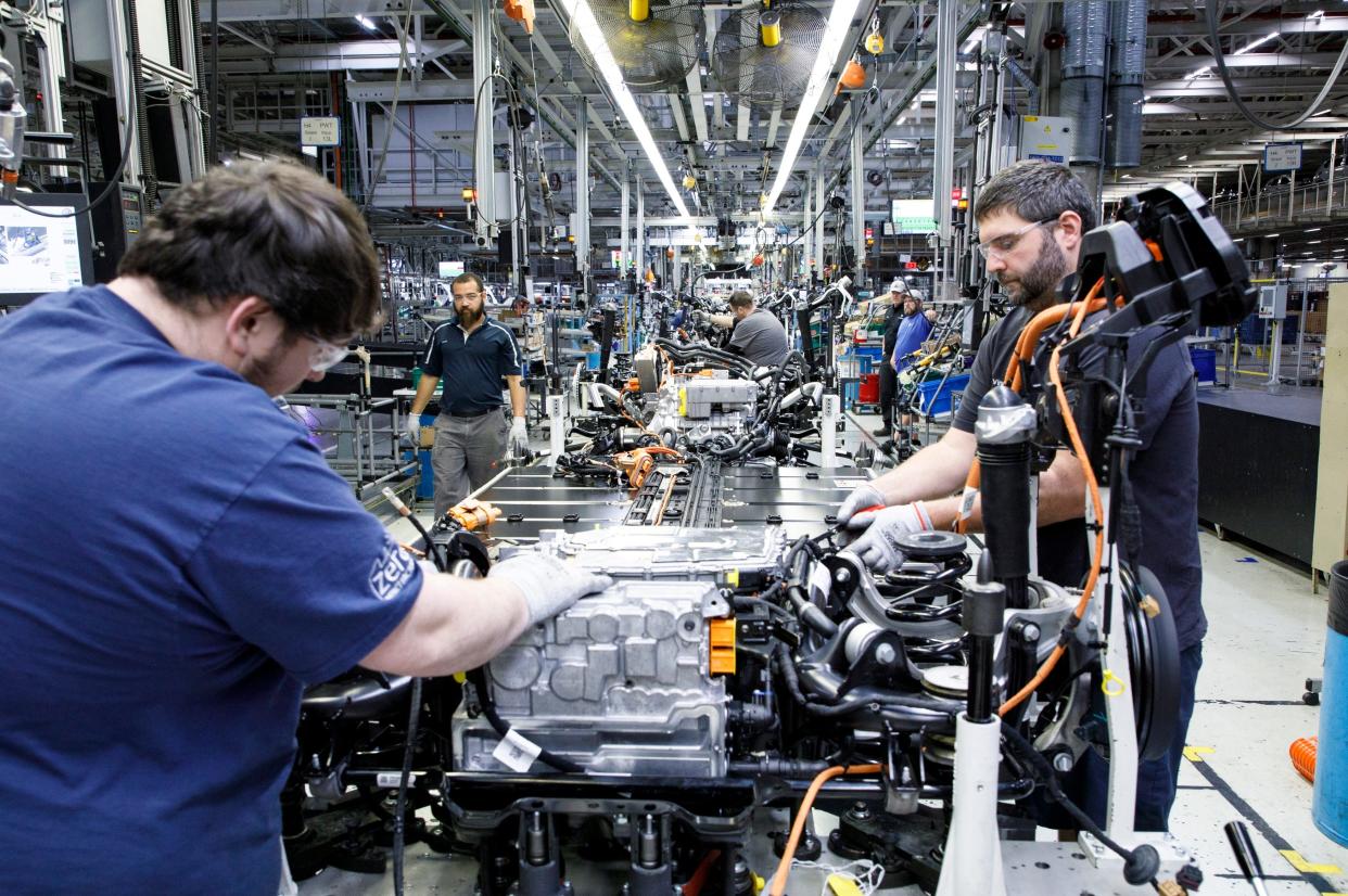 Workers add parts to a car at the Volkswagen plant in Chattanooga, Tenn.