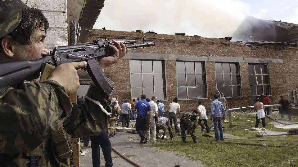 A soldier covers the roof as volunteers survey the area after special forces stormed a school seized by Chechen separatists on September 3, 2004 in the town of Beslan, Russia. - Oleg Nikishin/Getty Images