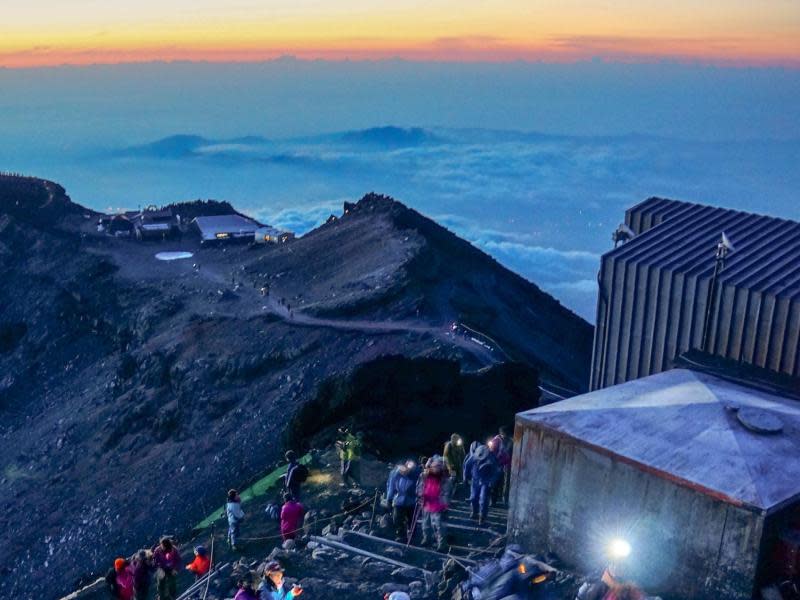 Mit Stirnlampe und Kamera: Warten auf den Sonnenaufgang am Gipfel des Fuji. Foto: Philipp Laage