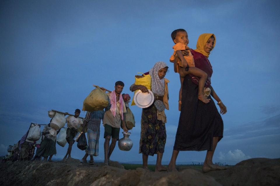 Thousands of Rohingya refugees walk along a rice field after crossing into Bangladesh in 2017. <a href="https://media.gettyimages.com/id/859402922/photo/rohingya-refugees-flood-into-bangladesh.jpg?s=1024x1024&w=gi&k=20&c=uIiWCvtJY1PXB1Z6VgmxRO53eC9U1TCKz2Psd7gp5wI=" rel="nofollow noopener" target="_blank" data-ylk="slk:Paula Bronstein/Getty Images;elm:context_link;itc:0;sec:content-canvas" class="link ">Paula Bronstein/Getty Images</a>