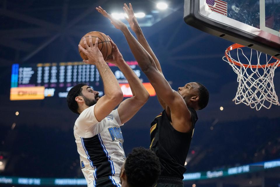 Orlando Magic center Goga Bitadze, left, shoots as Cleveland Cavaliers forward Evan Mobley defends during the first half of an NBA basketball game Wednesday, Dec. 6, 2023, in Cleveland. (AP Photo/Sue Ogrocki)