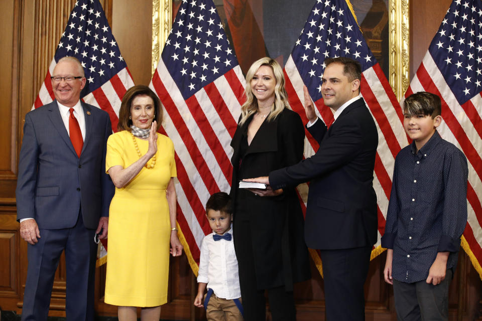 House Speaker Nancy Pelosi of Calif., second from left, conducts a ceremonial swearing-in for Rep. Mike Garcia, R-Calif., second from right, joined by his wife Rebecca and sons Jett, center, and Preston, on Capitol Hill in Washington, Tuesday, May 19, 2020. Standing alongside Pelosi is former Rep. Buck McKeon, R-Calif. (AP Photo/Patrick Semansky)