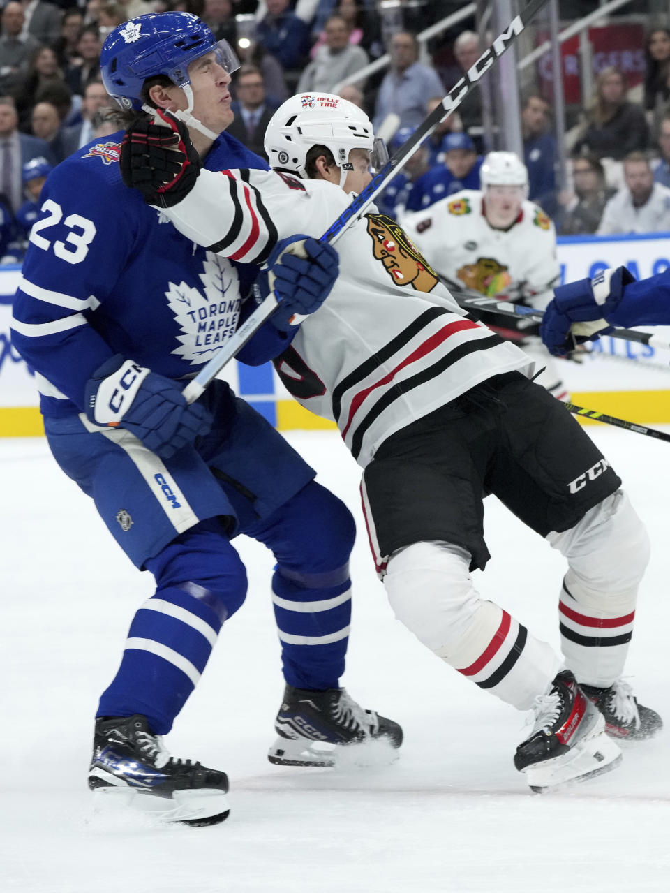 Toronto Maple Leafs left wing Matthew Knies (23) checks Chicago Blackhawks centre Connor Bedard, front right, during third-period NHL hockey game action in Toronto, Monday, Oct. 16, 2023. (Nathan Denette/The Canadian Press via AP)