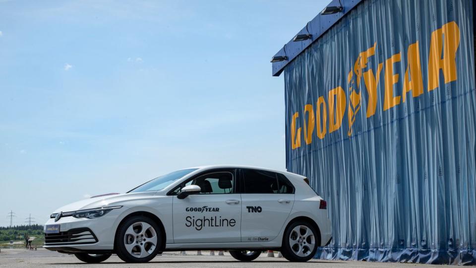 a white car parked in front of a large sign