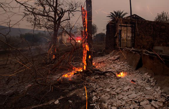 Wind-blown embers fly from a tree near a burnt-out house in Napa, California on October 9, 2017.