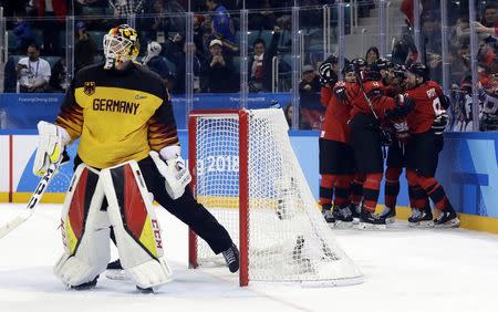 Ice Hockey - Pyeongchang 2018 Winter Olympics - Men Semifinal Match - Canada v Germany - Gangneung Hockey Centre, Gangneung, South Korea - February 23, 2018 - Goalie Danny Aus Den Birken of Germany looks on while Canada's players celebrate goal scored by teammate Derek Roy. REUTERS/David W Cerny