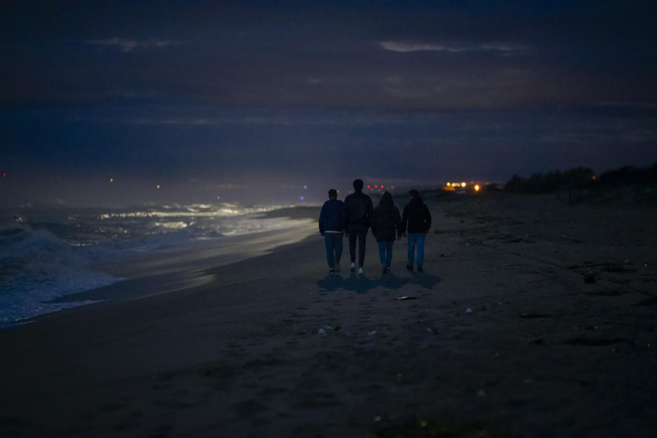 Survivors and relatives of the victims walk, Monday, Feb. 26, 2024, at the site where a migrant boat capsized in the early morning of Sunday, Feb. 26, 2023, at a short distance from the shore in Steccato di Cutro, in the Italian southern tip, killing at least 94 people. Survivors and family members of the victims gathered at the same time on the day of the disaster for a commemoration on the first anniversary. (AP Photo/Valeria Ferraro)