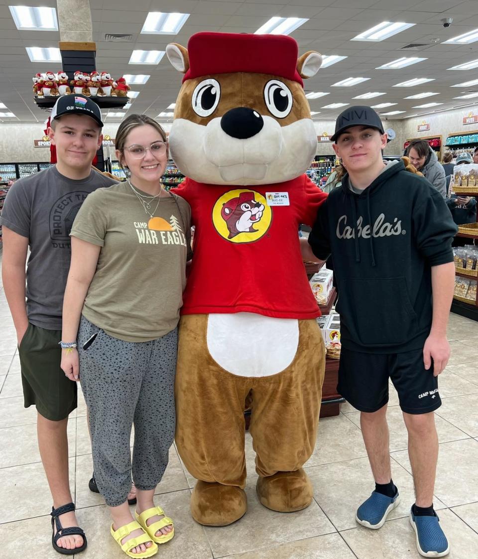 From left to right, Kolton Deere, Destinee Deere and Kody Deere of Harrison, Arkansas pose for a photo with the Buc-ee's mascot in Leeds, Alabama.