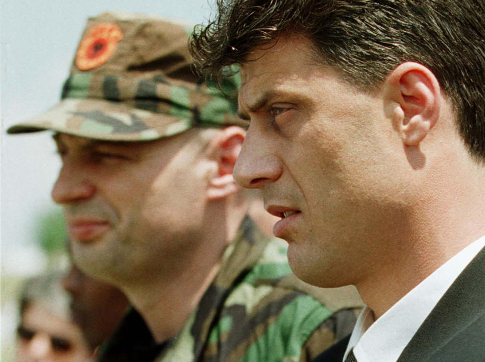 FILE - In this Friday Aug. 6, 1999 file photo, Kosovo Liberation Army leader Hashim Thaci, right, and KLA general commander Agim Ceku, left, attend a memorial ceremony for ethnic Albanian leader Fehmi Agani in Pristina, in the Yugoslav province of Kosovo. Kosovo's President Hashim Thaci, a guerrilla leader during Kosovo's war for independence from Serbia in the late 1990s, resigned on Thursday Nov. 5, 2020 and will face charges for war crimes and crimes against humanity at a special court based in The Hague. (AP Photo/Lefteris Pitarakis, File)