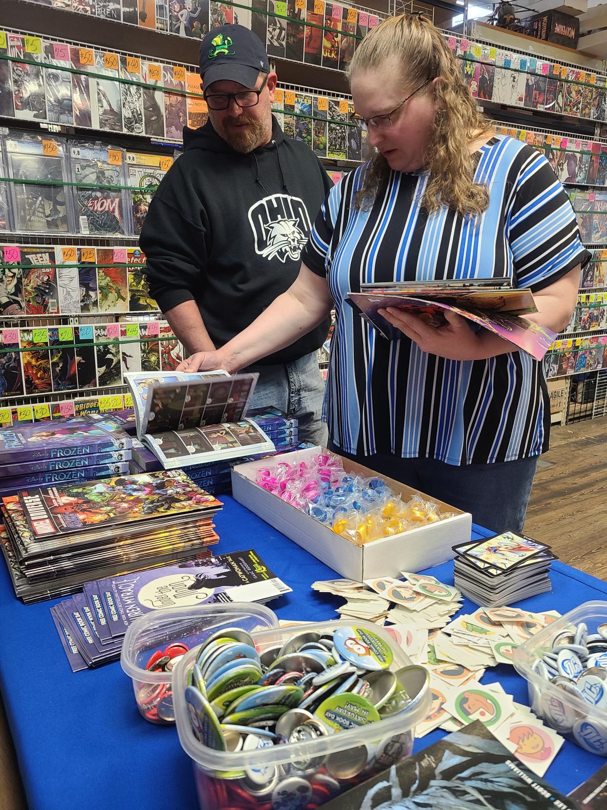 Cyndy and Don Britenburg look over books and buttons at Rupp's Comics.