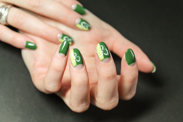 moon manicure gel polish with abstract bright and fashionable design with green shamrocks on the hands of a modern girl