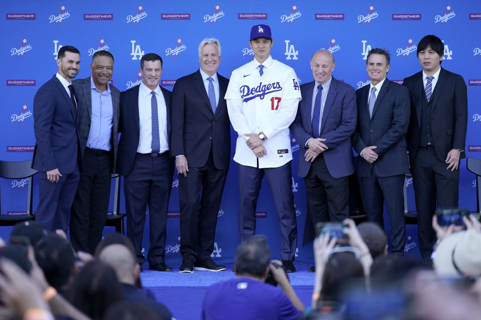 Los Angeles Dodgers' Shohei Ohtani (17) poses for photos with general manager Brandon Gomes, from left, manager Dave Roberts, president of baseball operations Andrew Friedman, owner & chairman Mark Walter, President & CEO Stan Kasten, agent Nez Balelo and interpreter Ippei Mizuhara during a news conference at Dodger Stadium Thursday, Dec. 14, 2023, in Los Angeles. (AP Photo/Ashley Landis)