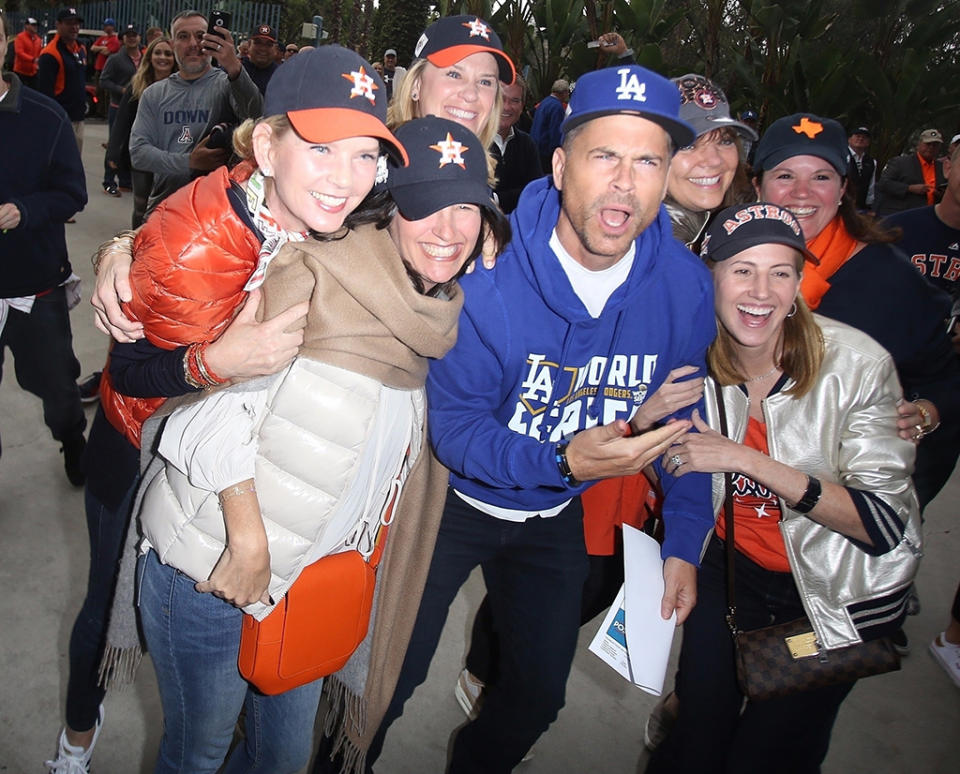 <p>Alhough he’s a diehard Dodgers supporter, the actor stopped to take photos with a large group of Houston Astros fans before Game 6 of the World Series on Tuesday in Los Angeles. Lucky for Rob, his team came out on top, forcing a Game 7. (Photo: GICA/Backgrid) </p>