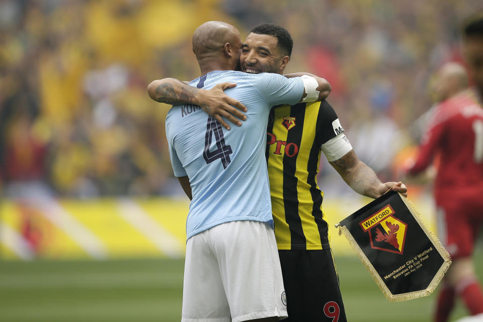 Manchester City's Vincent Kompany, left, hugs Watford's Troy Deeney before the English FA Cup Final soccer match between Manchester City and Watford at Wembley stadium in London, Saturday, May 18, 2019. (AP Photo/Tim Ireland)