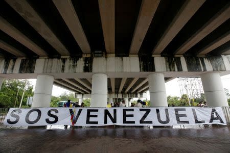 A banner is seen with a small group of Venezuelan protesters outside the site where the Organization of American States (OAS) 47th General Assembly is taking place in Cancun, Mexico June 21, 2017. REUTERS/Carlos Jasso
