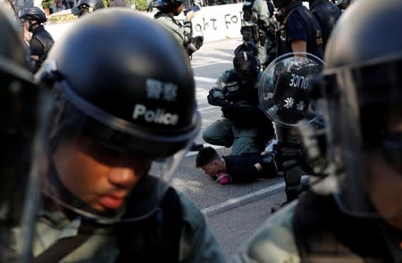 An anti-government protester is detained during a march in Tuen Mun, Hong Kong