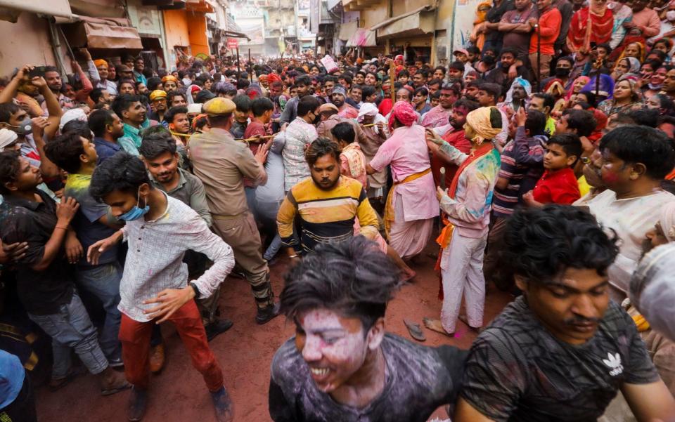 Police officers and locals try to control the crowd during Lathmar Holi celebrations, - ADNAN ABIDI/REUTERS