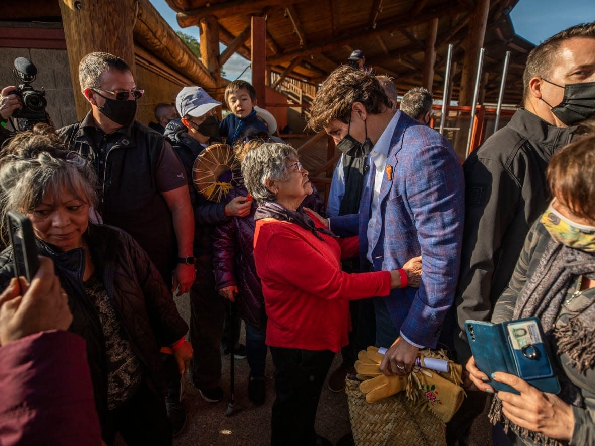 Prime Minister Justin Trudeau is held by a woman during a gathering outside the former Kamloops Indian Residential School on Monday.  (Ben Nelms/CBC - image credit)